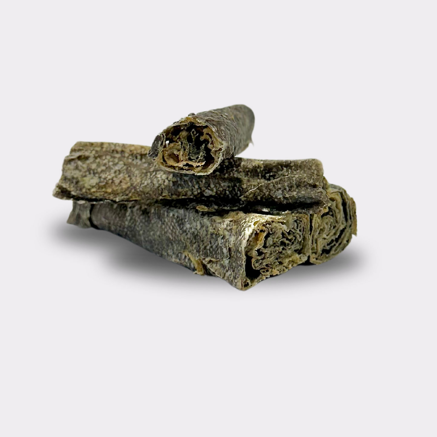 A stack of four cod fish skin rolls natural dog treats on an all white background.