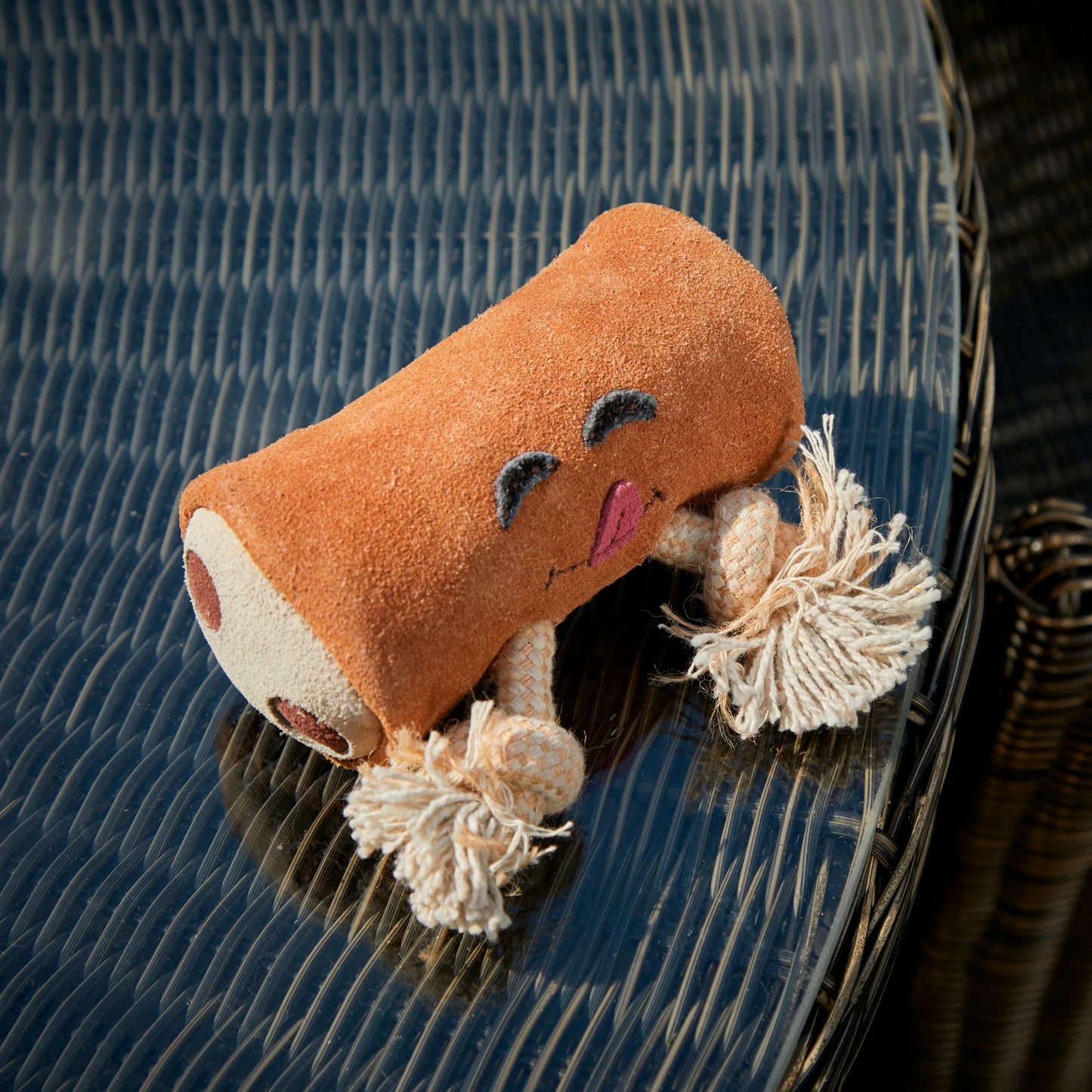 Plush eco dog toy resembling a chocolate bar on an outdoor table.