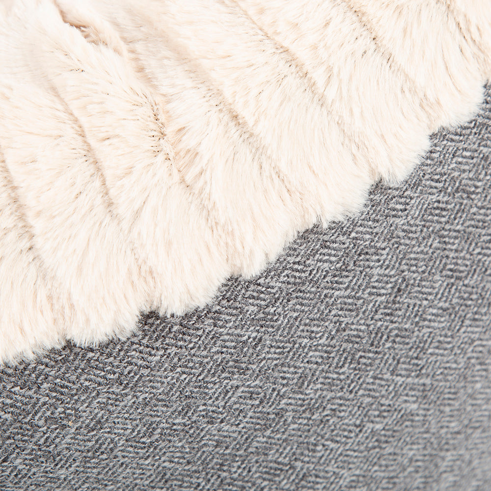Close-up of light grey tweed fabric and cream plush edge.