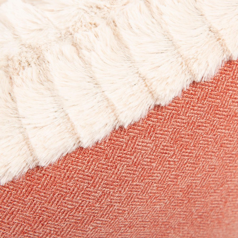 Close-up of terracotta red tweed fabric and cream plush trim.