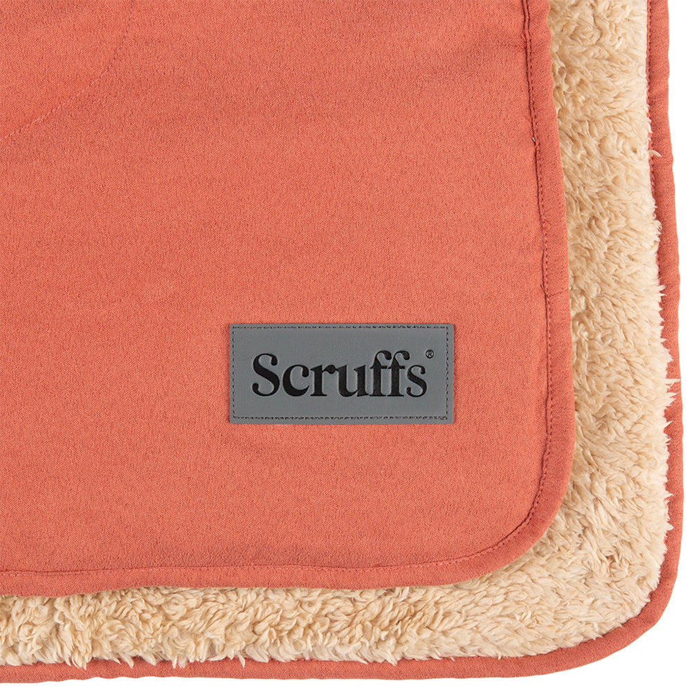 Close-up of Scruffs snuggle blanket in terracotta showing logo detail